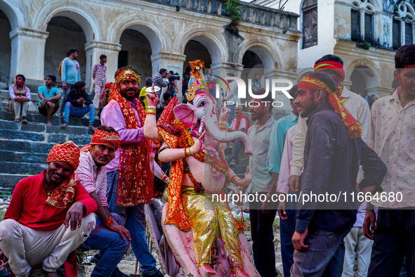 Hindu devotees immerse an idol of the Hindu goddess Durga into the Bagmati River in Kathmandu, Nepal, on October 14, 2024. In Hindu mytholog...