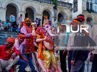 Hindu devotees immerse an idol of the Hindu goddess Durga into the Bagmati River in Kathmandu, Nepal, on October 14, 2024. In Hindu mytholog...