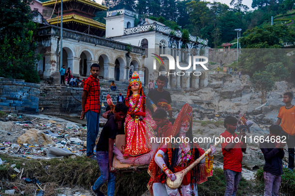 Hindu devotees immerse an idol of the Hindu goddess Durga into the Bagmati River in Kathmandu, Nepal, on October 14, 2024. In Hindu mytholog...