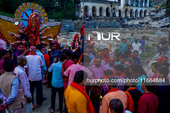 Hindu devotees immerse an idol of the Hindu goddess Durga into the Bagmati River in Kathmandu, Nepal, on October 14, 2024. In Hindu mytholog...