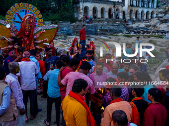 Hindu devotees immerse an idol of the Hindu goddess Durga into the Bagmati River in Kathmandu, Nepal, on October 14, 2024. In Hindu mytholog...