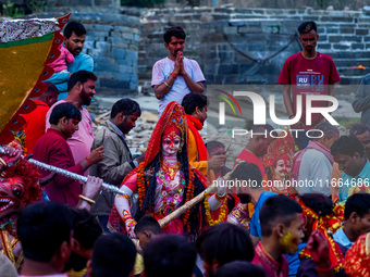 Hindu devotees immerse an idol of the Hindu goddess Durga into the Bagmati River in Kathmandu, Nepal, on October 14, 2024. In Hindu mytholog...