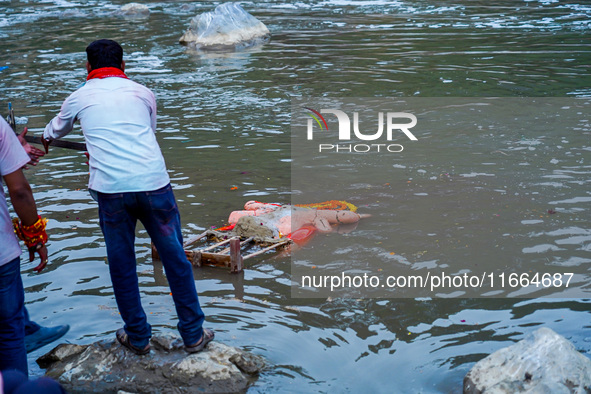 Hindu devotees immerse an idol of the Hindu goddess Durga into the Bagmati River in Kathmandu, Nepal, on October 14, 2024. In Hindu mytholog...