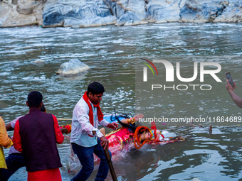 Hindu devotees immerse an idol of the Hindu goddess Durga into the Bagmati River in Kathmandu, Nepal, on October 14, 2024. In Hindu mytholog...