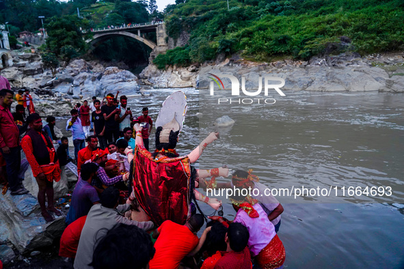 Hindu devotees immerse an idol of the Hindu goddess Durga into the Bagmati River in Kathmandu, Nepal, on October 14, 2024. In Hindu mytholog...