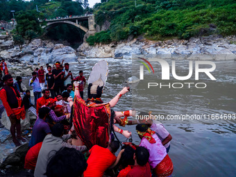 Hindu devotees immerse an idol of the Hindu goddess Durga into the Bagmati River in Kathmandu, Nepal, on October 14, 2024. In Hindu mytholog...