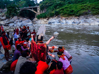 Hindu devotees immerse an idol of the Hindu goddess Durga into the Bagmati River in Kathmandu, Nepal, on October 14, 2024. In Hindu mytholog...