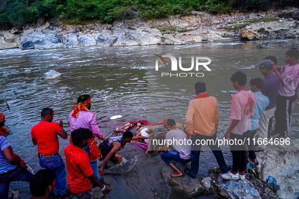 Hindu devotees immerse an idol of the Hindu goddess Durga into the Bagmati River in Kathmandu, Nepal, on October 14, 2024. In Hindu mytholog...