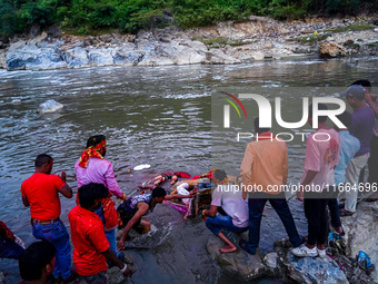 Hindu devotees immerse an idol of the Hindu goddess Durga into the Bagmati River in Kathmandu, Nepal, on October 14, 2024. In Hindu mytholog...