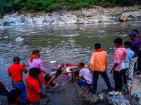 Hindu devotees immerse an idol of the Hindu goddess Durga into the Bagmati River in Kathmandu, Nepal, on October 14, 2024. In Hindu mytholog...