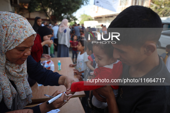 Palestinian children receive drops as part of a polio vaccination campaign in Deir al-Balah, Gaza Strip, on October 14, 2024, amid the ongoi...