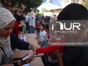 Palestinian children receive drops as part of a polio vaccination campaign in Deir al-Balah, Gaza Strip, on October 14, 2024, amid the ongoi...