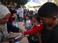 Palestinian children receive drops as part of a polio vaccination campaign in Deir al-Balah, Gaza Strip, on October 14, 2024, amid the ongoi...