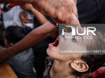 Palestinian children receive drops as part of a polio vaccination campaign in Deir al-Balah, Gaza Strip, on October 14, 2024, amid the ongoi...