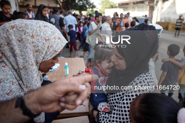 Palestinian children receive drops as part of a polio vaccination campaign in Deir al-Balah, Gaza Strip, on October 14, 2024, amid the ongoi...