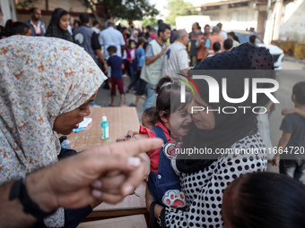 Palestinian children receive drops as part of a polio vaccination campaign in Deir al-Balah, Gaza Strip, on October 14, 2024, amid the ongoi...