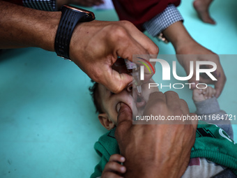 Palestinian children receive drops as part of a polio vaccination campaign in Deir al-Balah, Gaza Strip, on October 14, 2024, amid the ongoi...