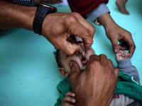 Palestinian children receive drops as part of a polio vaccination campaign in Deir al-Balah, Gaza Strip, on October 14, 2024, amid the ongoi...