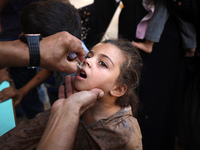 Palestinian children receive drops as part of a polio vaccination campaign in Deir al-Balah, Gaza Strip, on October 14, 2024, amid the ongoi...