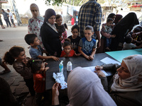 Palestinian children receive drops as part of a polio vaccination campaign in Deir al-Balah, Gaza Strip, on October 14, 2024, amid the ongoi...