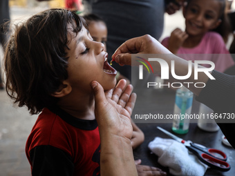 Palestinian children receive drops as part of a polio vaccination campaign in Deir al-Balah, Gaza Strip, on October 14, 2024, amid the ongoi...