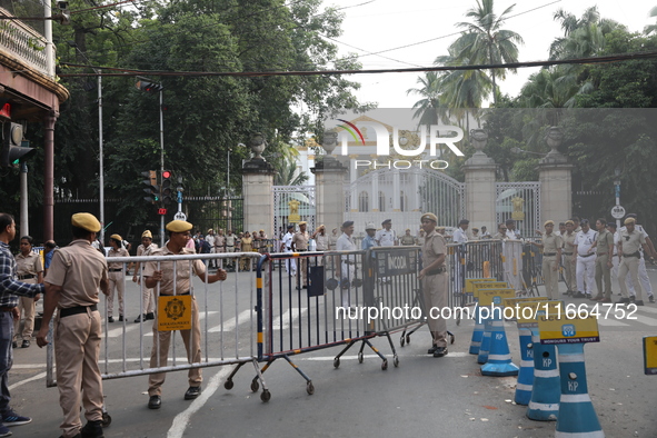 Police officers block a road in front of the Governor's house while doctors and citizens shout slogans during a protest march demanding that...