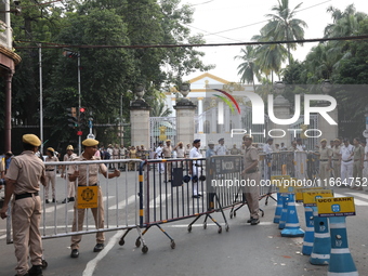 Police officers block a road in front of the Governor's house while doctors and citizens shout slogans during a protest march demanding that...