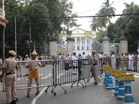 Police officers block a road in front of the Governor's house while doctors and citizens shout slogans during a protest march demanding that...