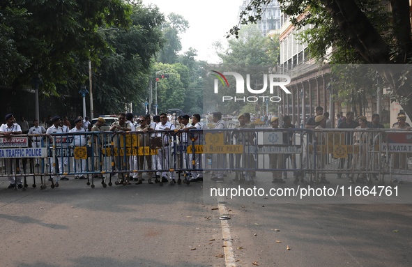 Police officers block a road in front of the Governor's house while doctors and citizens shout slogans during a protest march demanding that...