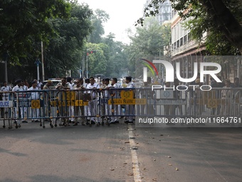 Police officers block a road in front of the Governor's house while doctors and citizens shout slogans during a protest march demanding that...