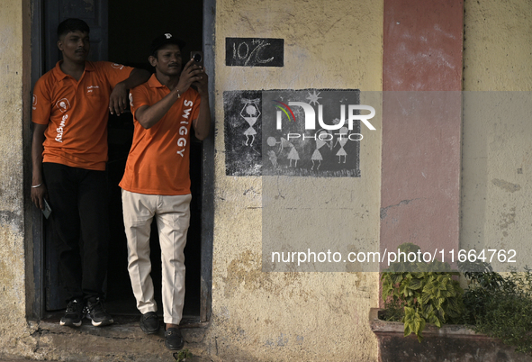 A Swiggy delivery person takes a mobile photograph at an event in Mumbai, India, on October 14, 2024. IPO-bound Swiggy launches an XL fleet...