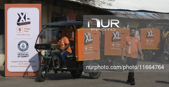 Swiggy gig workers ride electric three-wheelers during a promotional event in Mumbai, India, on October 14, 2024. IPO-bound Swiggy launches...