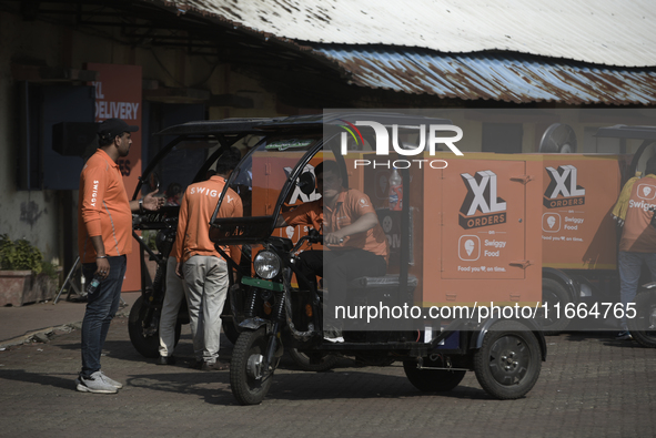 Swiggy gig workers ride electric three-wheelers during a promotional event in Mumbai, India, on October 14, 2024. IPO-bound Swiggy launches...