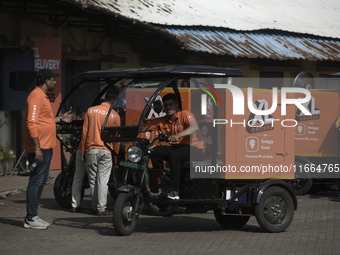 Swiggy gig workers ride electric three-wheelers during a promotional event in Mumbai, India, on October 14, 2024. IPO-bound Swiggy launches...