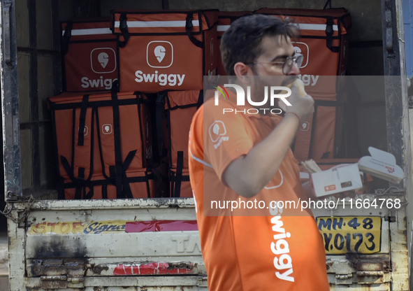 A Swiggy gig worker eats 'Vada Pav', an Indian snack, during a promotional event in Mumbai, India, on October 14, 2024. IPO-bound Swiggy lau...