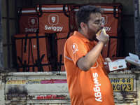 A Swiggy gig worker eats 'Vada Pav', an Indian snack, during a promotional event in Mumbai, India, on October 14, 2024. IPO-bound Swiggy lau...