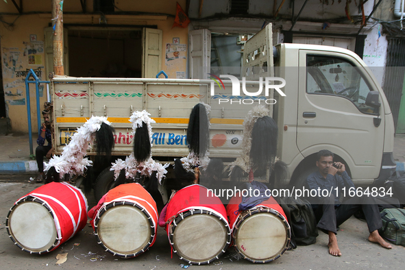 Traditional Bengali drum players, known as Dhaki, gather on a footpath in North Kolkata, India, on October 14, 2024, as temporary shelters w...