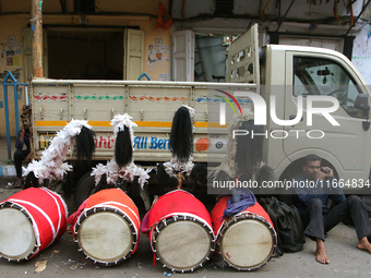 Traditional Bengali drum players, known as Dhaki, gather on a footpath in North Kolkata, India, on October 14, 2024, as temporary shelters w...