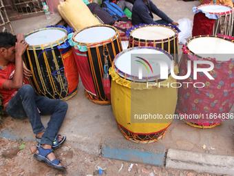 Traditional Bengali drum players, commonly known as Dhakis, gather on a footpath in North Kolkata, India, as temporary shelters and wait for...