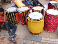 Traditional Bengali drum players, commonly known as Dhakis, gather on a footpath in North Kolkata, India, as temporary shelters and wait for...