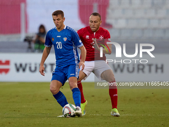 In Ta' Qali, Malta, on October 13, 2024, Sergiu Platica of Moldova is closely followed by Ryan Camenzuli of Malta during the UEFA Nations Le...