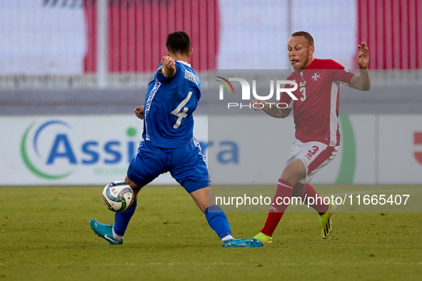 In Ta' Qali, Malta, on October 13, 2024, Ryan Camenzuli of Malta is confronted by Vladislav Babogio of Moldova during the UEFA Nations Leagu...