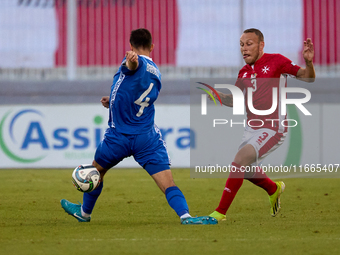 In Ta' Qali, Malta, on October 13, 2024, Ryan Camenzuli of Malta is confronted by Vladislav Babogio of Moldova during the UEFA Nations Leagu...