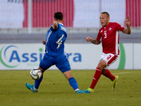 In Ta' Qali, Malta, on October 13, 2024, Ryan Camenzuli of Malta is confronted by Vladislav Babogio of Moldova during the UEFA Nations Leagu...