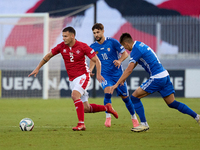 In Ta' Qali, Malta, on October 13, 2024, Jean Borg of Malta moves away from Vitalie Damascan and Mihail Caimacov of Moldova during the UEFA...