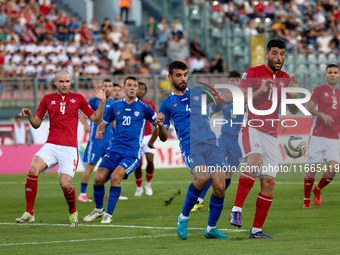 In Ta' Qali, Malta, on October 13, 2024, Luke Montebello of Malta is closely challenged by Vladislav Babogio of Moldova during the UEFA Nati...