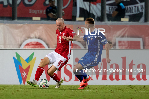 In Ta' Qali, Malta, on October 13, 2024, Trent Buhagiar of Malta is closely followed by Oleg Reabciuk of Moldova during the UEFA Nations Lea...