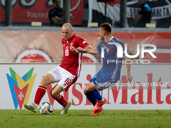 In Ta' Qali, Malta, on October 13, 2024, Trent Buhagiar of Malta is closely followed by Oleg Reabciuk of Moldova during the UEFA Nations Lea...