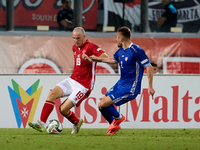 In Ta' Qali, Malta, on October 13, 2024, Trent Buhagiar of Malta is closely followed by Oleg Reabciuk of Moldova during the UEFA Nations Lea...