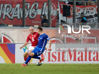 In Ta' Qali, Malta, on October 13, 2024, Trent Buhagiar of Malta is closely followed by Oleg Reabciuk of Moldova during the UEFA Nations Lea...